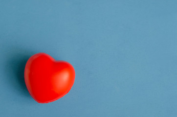 volumetric red heart on a light blue wooden heterogeneous background