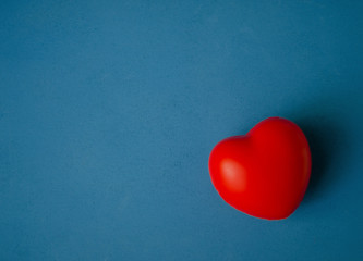 volumetric red heart on a dark blue wooden heterogeneous background