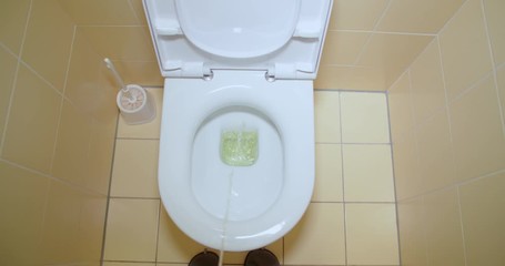 Slow motion shot, peeing, urinating in toilet, first person view. Stream of urine flows into the bowl closeup.