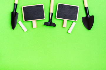 Home gardening. Miniature gardening tools: a scoop, a rake, a writing board and chalk are laid out...