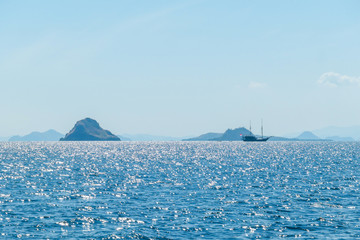 Sunbeams breaking out through the clouds and reaching the calm surface of the sea in Komodo...