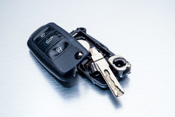 Close-up dirty broken or damaged car key fob on aluminium background locksmith service.- Image