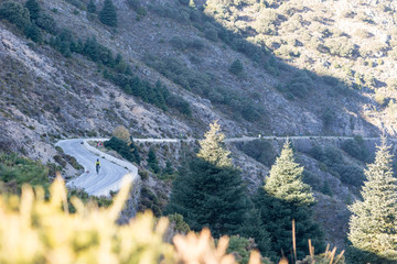 Cyclist climbing up a winding mountain road in southern Spain.