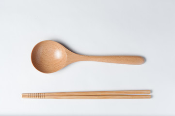 Cutlery made of wood. Wooden spoon and wooden chinese sticks on a white background.