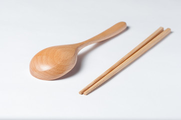 Cutlery made of wood. Wooden spoon and wooden chinese sticks on a white background.