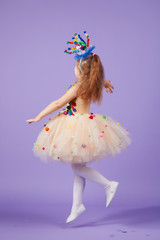 Children's birthday party, masquerade. Little happy toddler child girl in a puffy tutu fancy dress,...