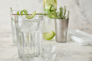 Glass of cold cucumber water on white background
