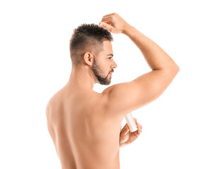 Fototapeta premium Handsome young man using deodorant on white background