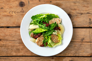 Overhead view of salad with roasted turkey, dried tomato, gorgonzola, canned pear and pine nuts