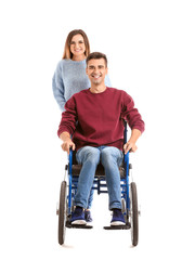 Fototapeta na wymiar Handicapped young man in wheelchair and his wife on white background