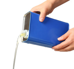 Pouring of car oil from canister against white background