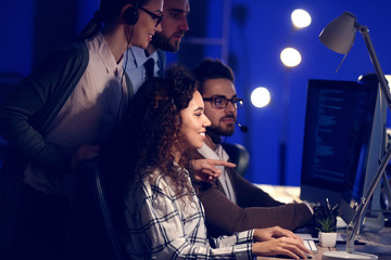 Technical support agents working in office at night