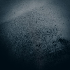 Glass covered with drops of water on a dark background, blurred background in blue tonality.