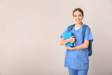 Female medical student on light background