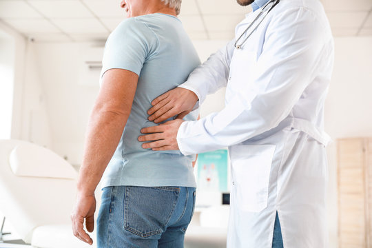 Urologist examining mature patient in clinic