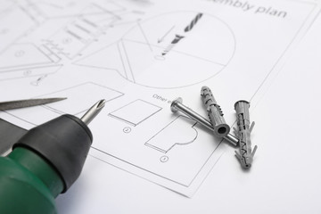 Furniture assembling plan with electric screwdriver, closeup