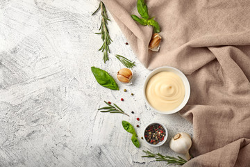 Obraz na płótnie Canvas Bowl with tasty sauce, spices and herbs on light background