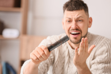 Man with hair loss problem at home