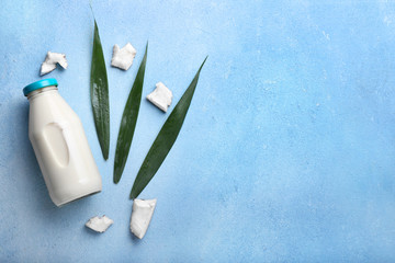 Bottle of coconut milk on color background