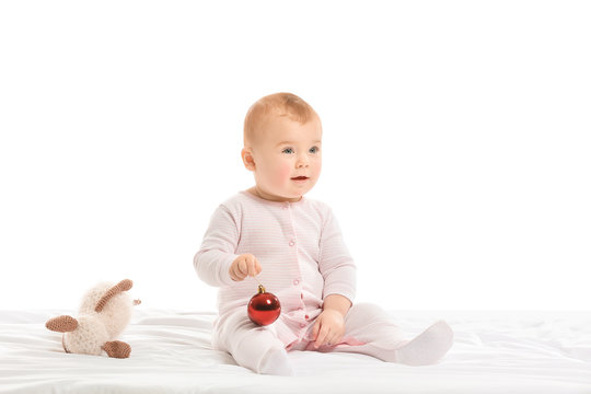 Cute little baby with Christmas ball and toy on white background