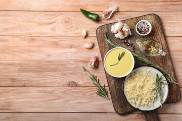 Bowl with tasty sauce and ingredients on wooden background