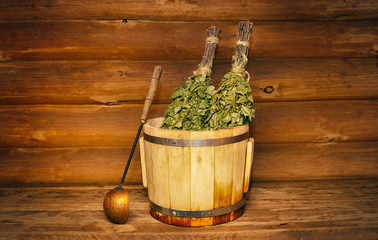 Brooms with dried herbs in a wooden bath. Relaxation concept.