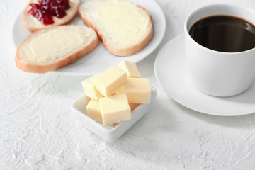 Tasty butter with bread and coffee on white background