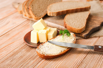 Bread with tasty butter on wooden table