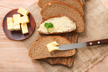 Slices of bread with tasty butter on wooden table