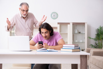 Obraz premium Old father helping his son in exam preparation
