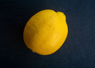 a yellow lemon in front of a black background
