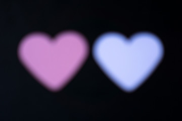 a blurry white and pink heart in front of a black background