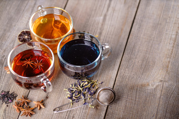 Collection of brewed green, cinnamon anise spiced and blue anchan tea in glass mugs. Tea shop and cafes