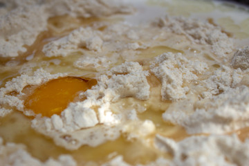 Unmixed ingredients of bread dough: eggs, wheat flour, oil and yeast