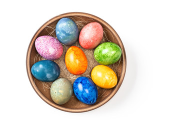 Different easter eggs in ceramic bowl isolated on white