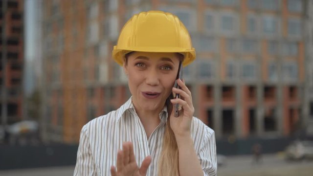 close-up, business woman architect talking on the phone. lady in a hard hat 4K
