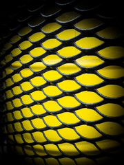 Texture of a beautiful black fence made of lattice on a bright yellow background