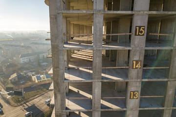 Aerial view of concrete frame of tall apartment building under construction in a city.
