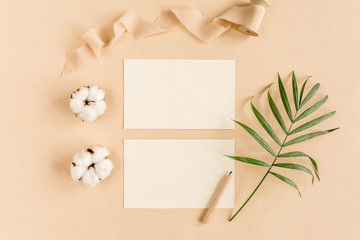 Mockup invitation, blank greeting card and tropical palm leaves. Flat lay, top view.