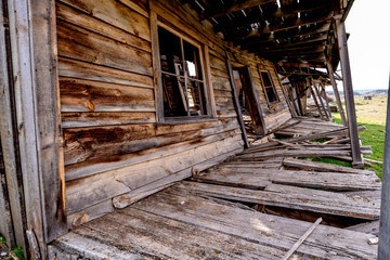 Broken down wooding western building with leaning walls falling down