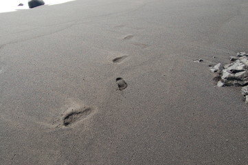 Footprints in black sand