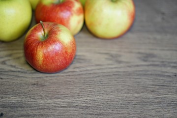 Red and green fresh apple fruit on the wood table.