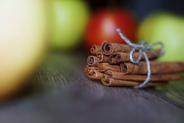 Juicy colorful apples and cinnamon on wood table.