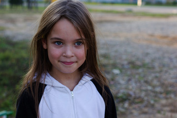 Cute little girl with dark hair is smiling.