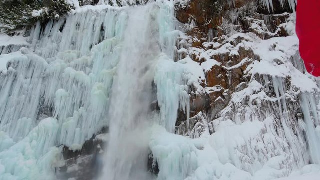 Travel Blogger Taking Photographs of Frozen Waterfall Icicles