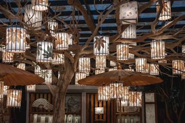 Decorated souvenir bookstore in Chongqing. Decorative umbrellas and lanterns on the tree. Unique interior design of the small boutique. Arts decorations concept.
