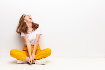 yound blonde woman screaming furiously, shouting aggressively, looking stressed and angry sitting on the floor © kues1