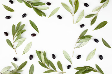 Top view of fresh black olive fruit with leaves on white background.