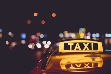 Abwaschbare Fototapete New York TAXI Nahaufnahme eines Taxizeichens auf einem Taxi während der Nachtzeit