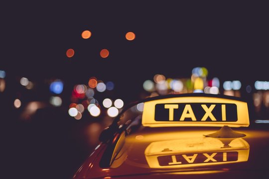 Closeup of a taxi sign on a cab during night time